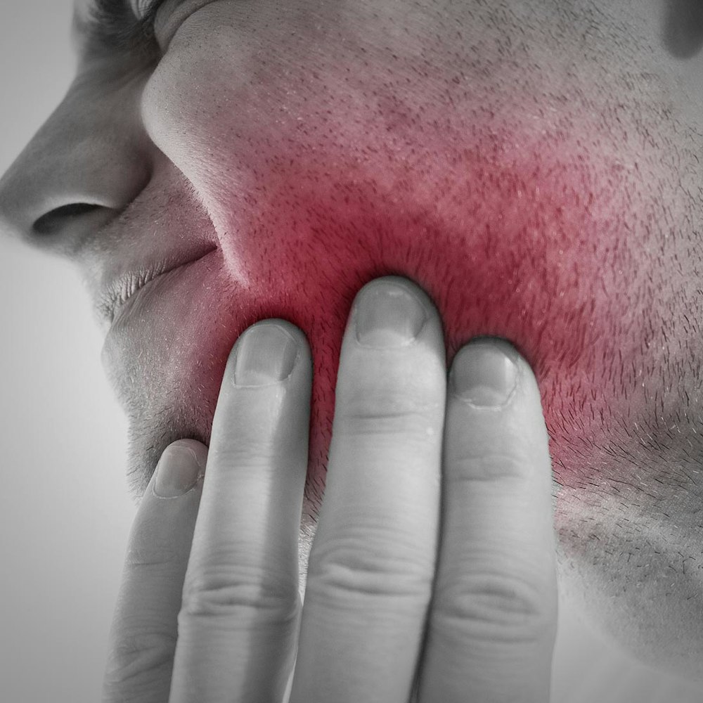 Woman holding hand to jaw in pain