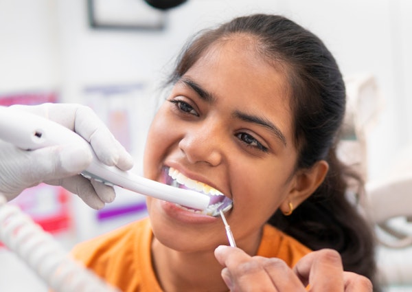 Young girl getting her teeth examined with an intraoral camera