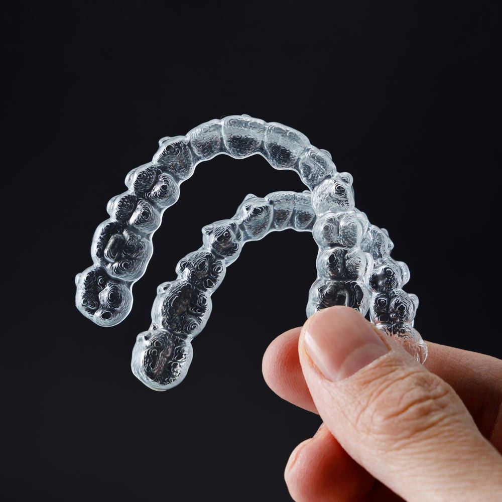 Person holding two Invisaligns